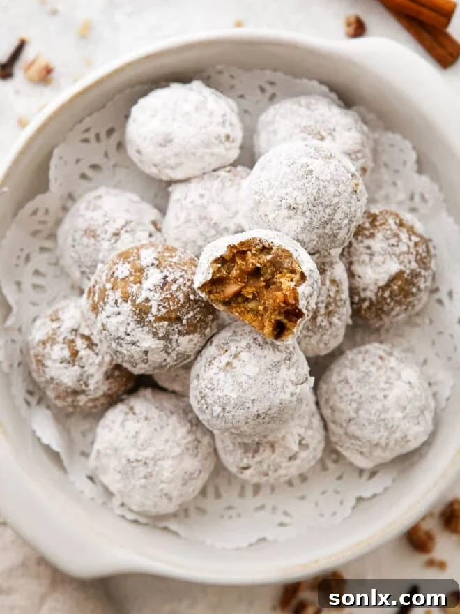 A beautifully crafted molasses spice snowball cookie with a gentle bite taken out, revealing its rich, spiced interior and visible chopped nuts. It rests invitingly in a rustic bowl filled with other perfectly round, powdered sugar-dusted cookies.
