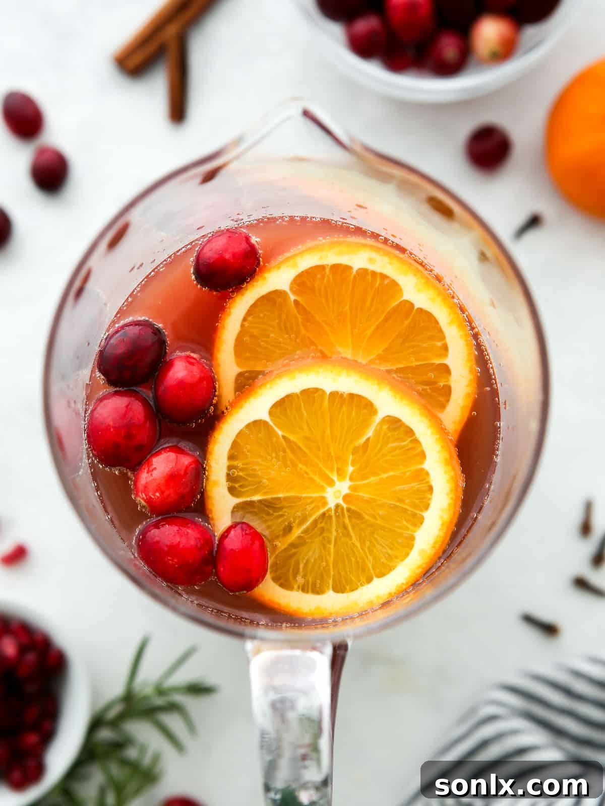 pitcher of holiday punch with cranberries and orange slices