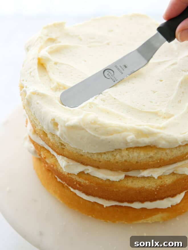 Frosting vanilla cake layers during cake assembly process