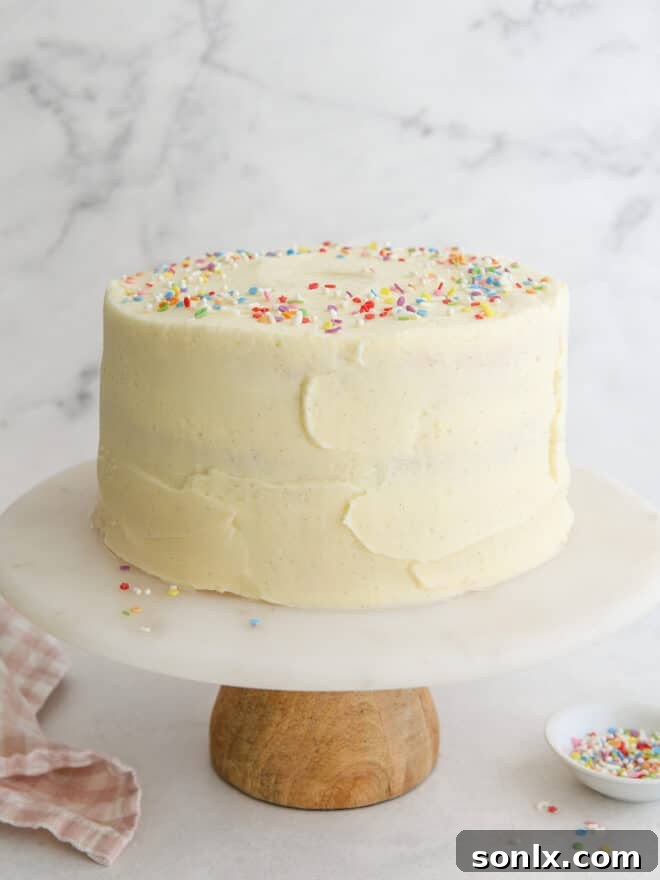 A beautifully frosted vanilla layer cake on a cake stand