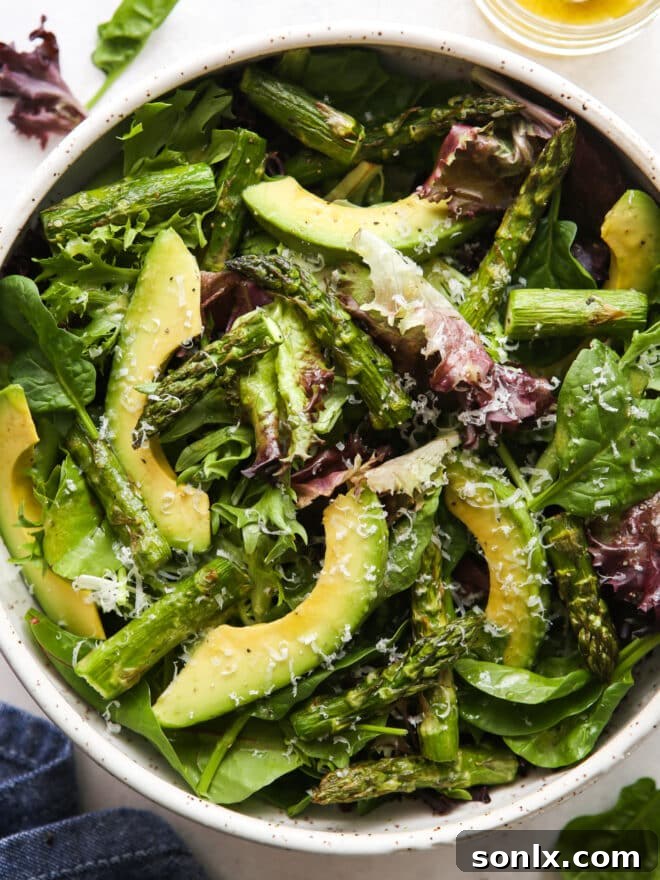 A detailed close-up of the roasted asparagus and avocado salad, showcasing its textures and fresh ingredients.