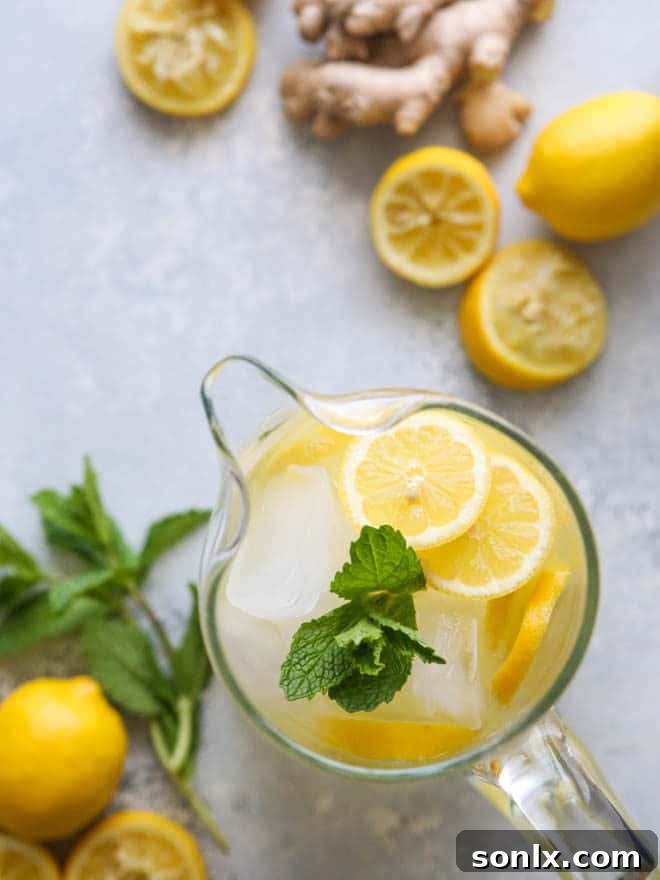 Citrus Zing with a Ginger Kick 2 Refreshing homemade ginger lemonade served in a glass pitcher with lemon slices and mint leaves, perfect for spring and summer