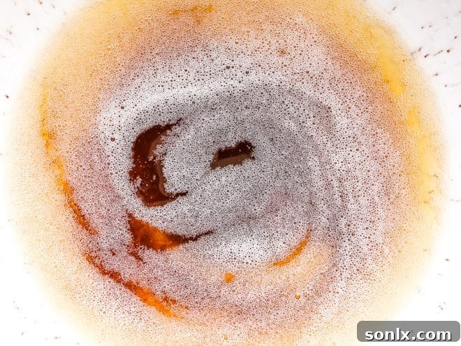 Butter browning in a saucepan, showcasing the golden flecks and rich color that indicate perfectly browned butter.