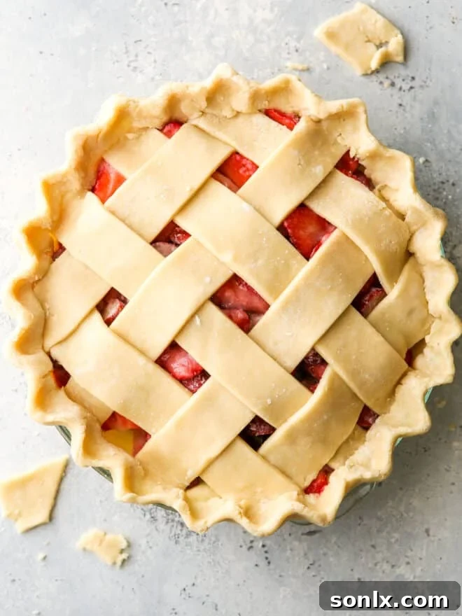 Fruit pie with lattice crust, brushed with egg wash and ready for baking