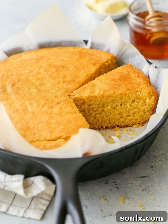 Golden brown honey buttermilk cornbread in a cast iron skillet, ready to be served.