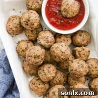 Pork quinoa meatballs beautifully arranged with a bowl of marinara sauce, ready to be served.
