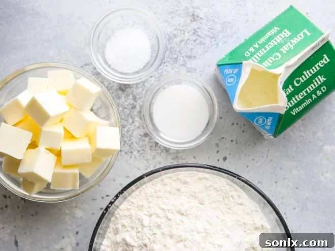 Fresh ingredients laid out for baking, including flour, cold butter, and a measuring cup of buttermilk, ready to be combined for a delicious pie crust.