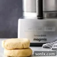 Two disks of pie crust next to a food processor