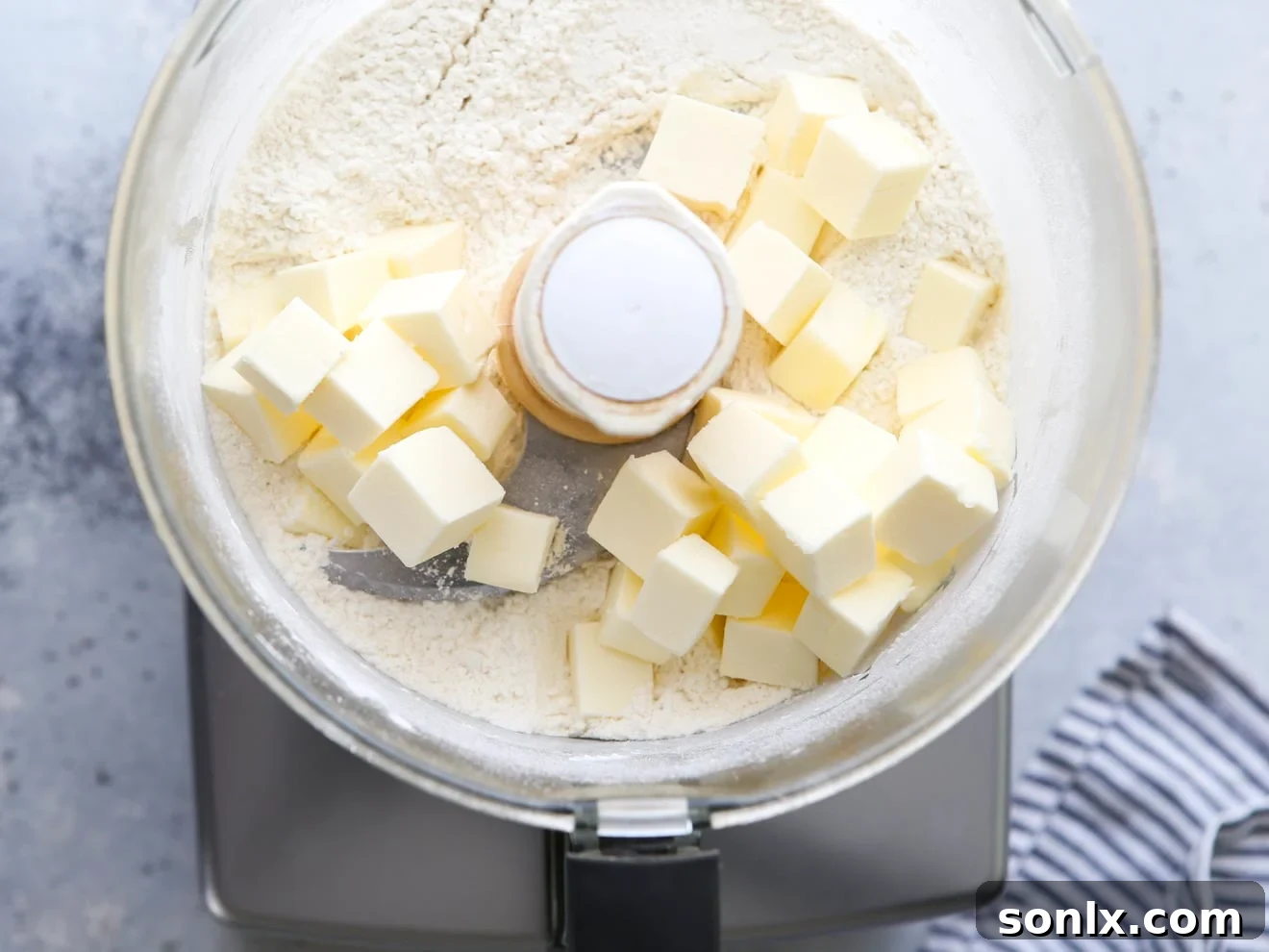 Cubed cold butter added to the dry ingredients in a food processor.