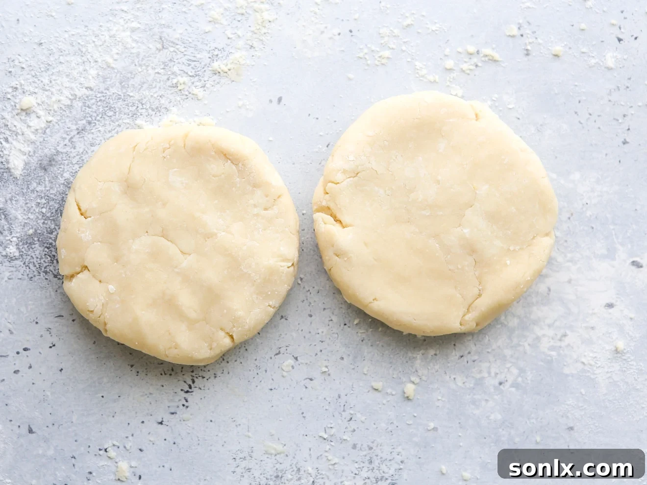 Two disks of pie dough formed on a clean surface.