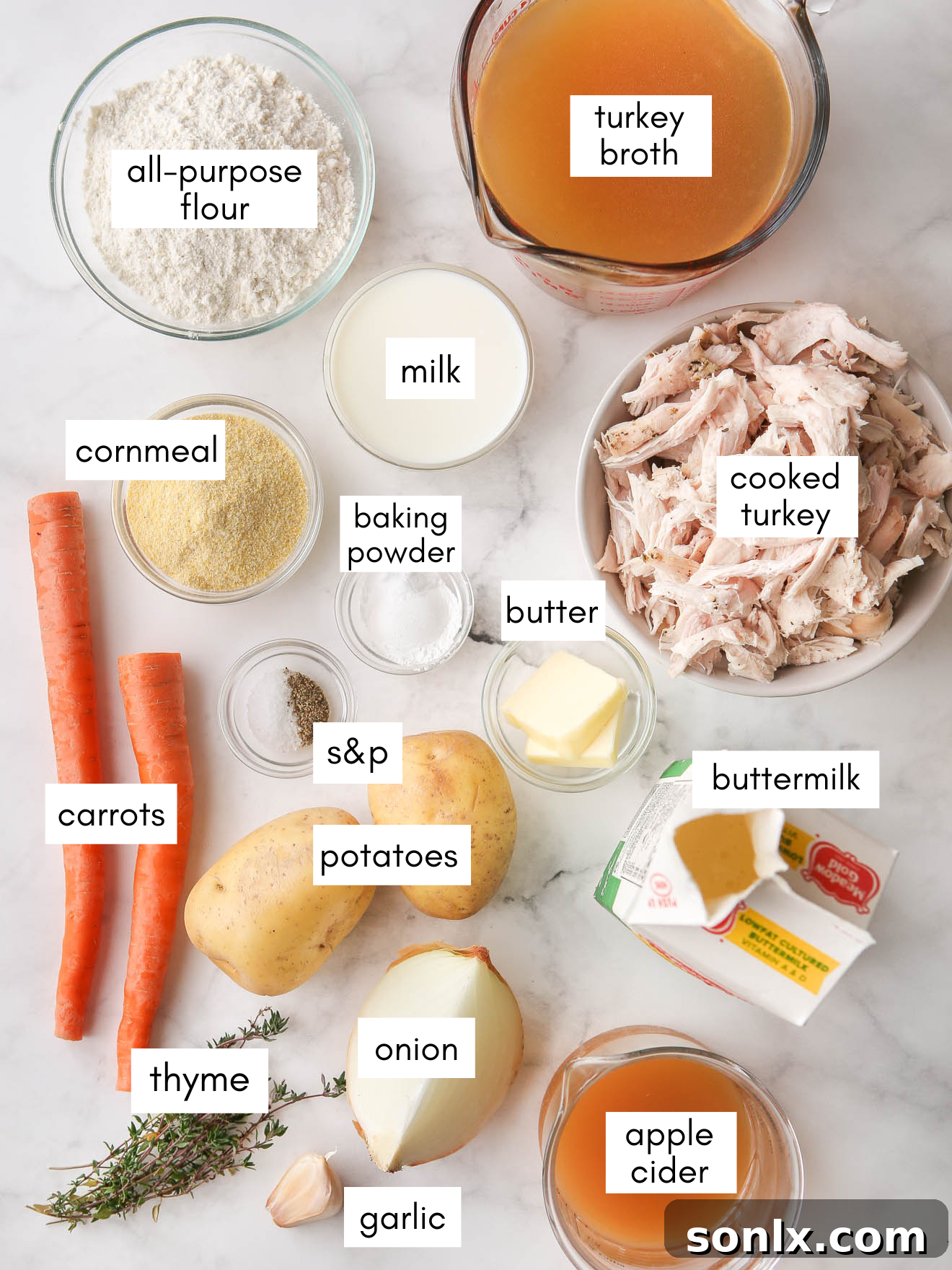 A selection of fresh ingredients including cooked turkey, carrots, onions, potatoes, garlic, thyme, apple cider, and buttermilk, laid out for turkey dumplings soup.