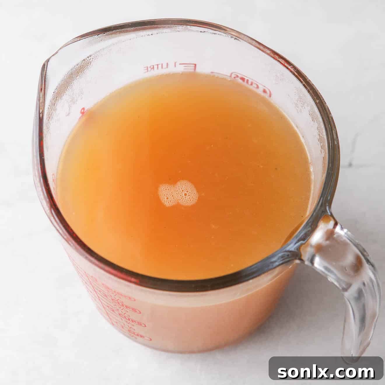 Freshly strained homemade turkey broth in a large bowl, ready for use or storage.