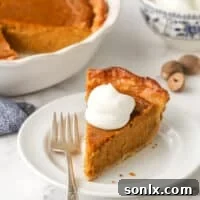 A beautifully baked Classic Pumpkin Pie, garnished with whipped cream, ready for serving.