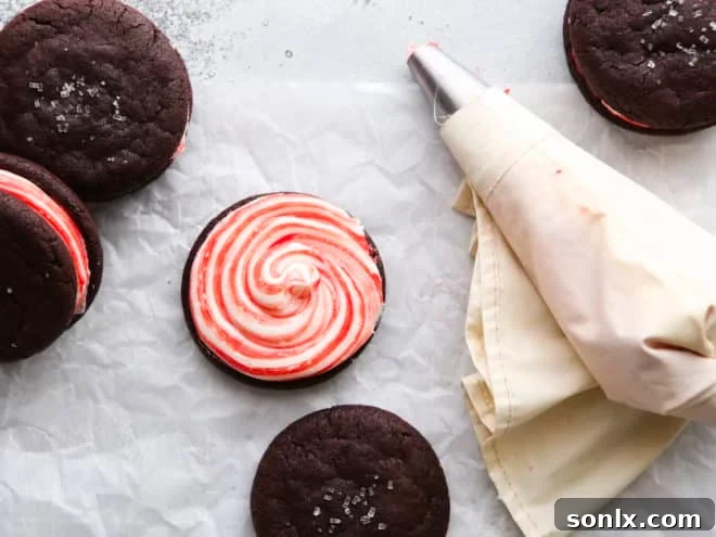 piping candy cane frosting onto a chocolate cookie