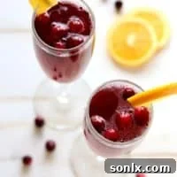 A festive Cranberry Orange Mimosa with garnishes.