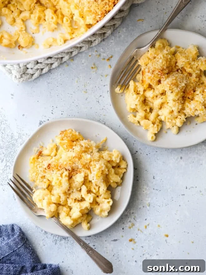 Classic baked macaroni and cheese served on plates with forks, ready to be enjoyed.