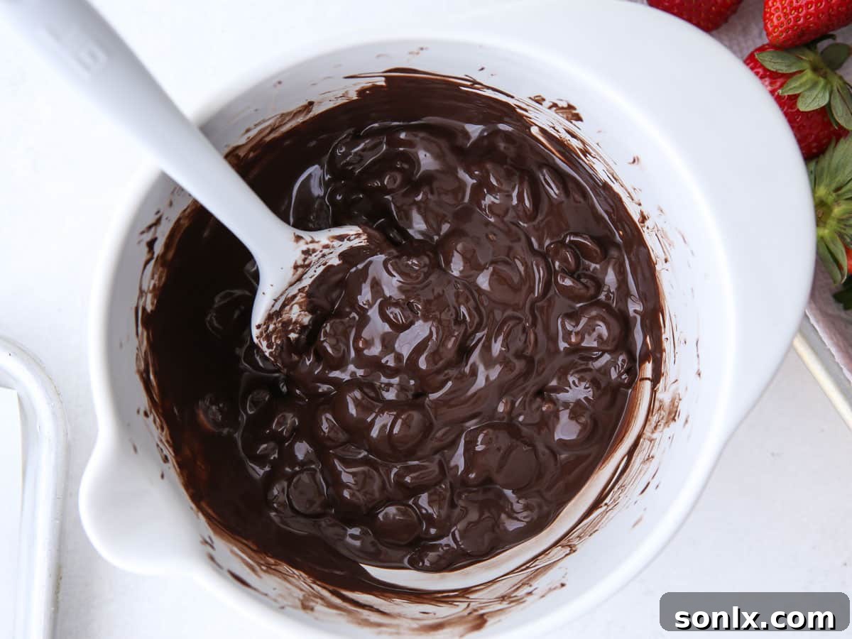 Close-up of chocolate melting in a white bowl, showing its smooth, glossy texture.