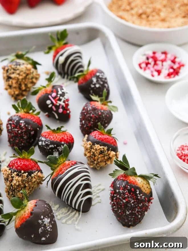 A close-up of beautifully tempered chocolate-covered strawberries, showcasing their glossy shine and vibrant toppings.
