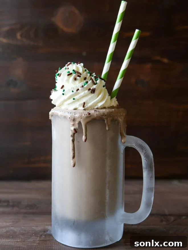 Boozy Crème de Menthe Milkshake in a frosty mug with whipped cream and sprinkles