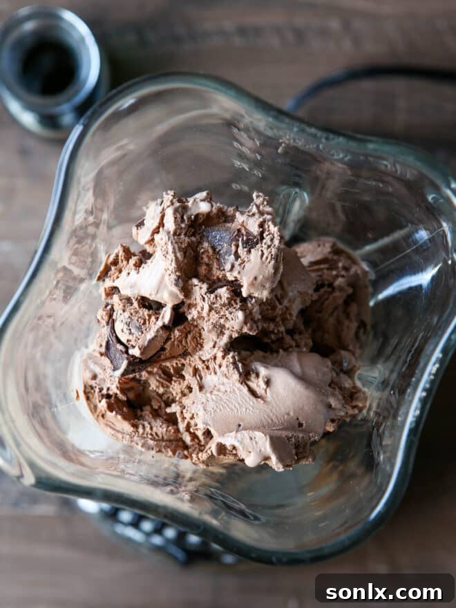 Chocolate ice cream being scooped into a blender