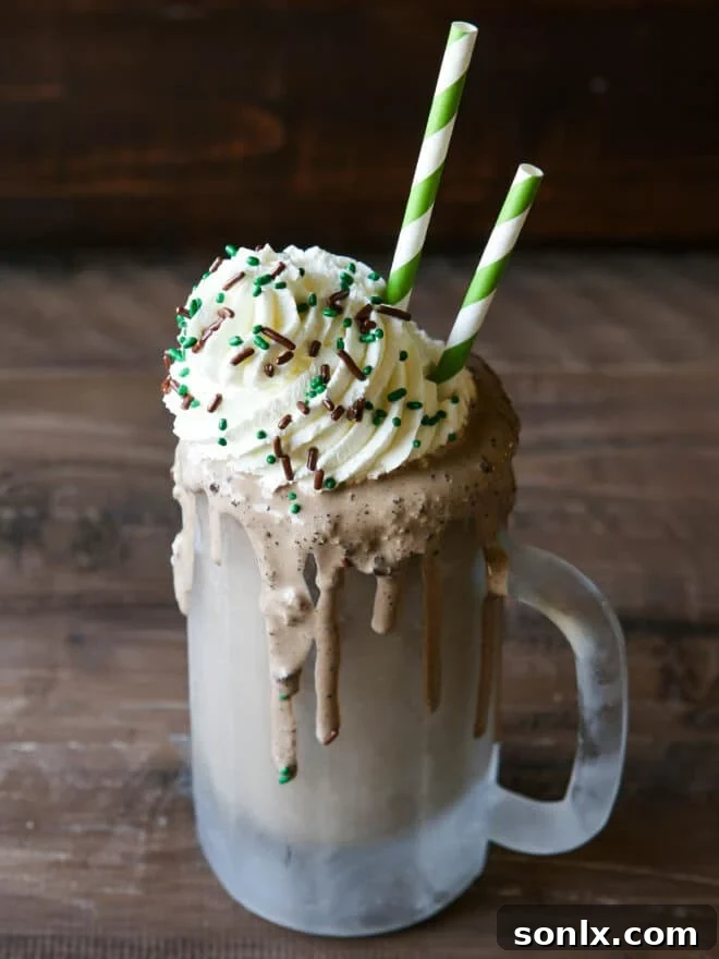 Close-up of a Boozy Crème de Menthe Milkshake in a frosty mug with whipped cream and sprinkles