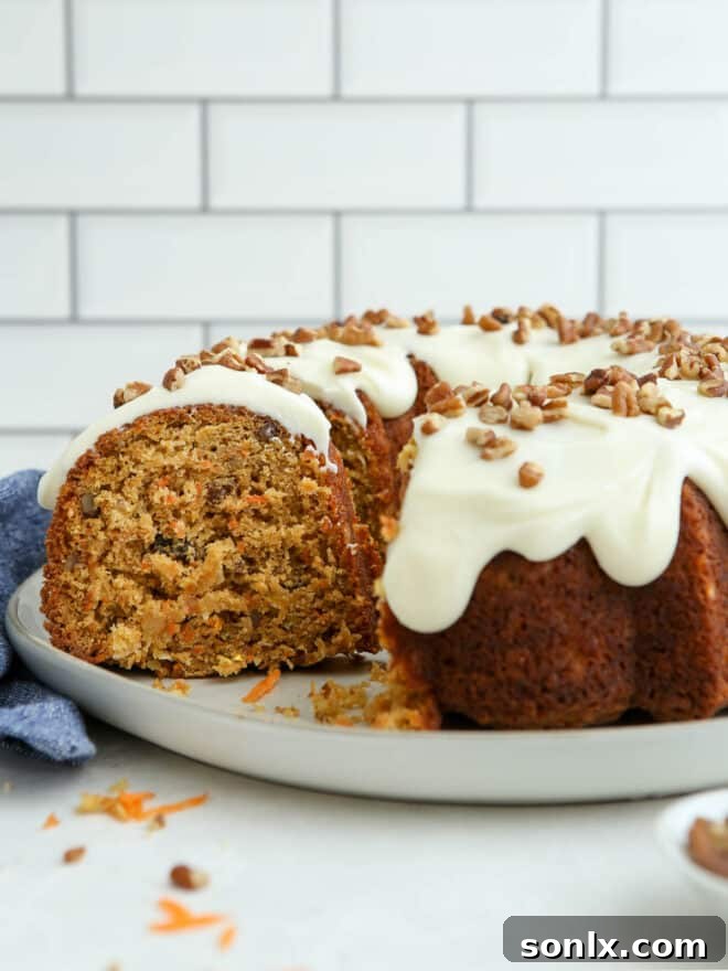 A whole brown butter carrot bundt cake with cream cheese icing on a serving plate