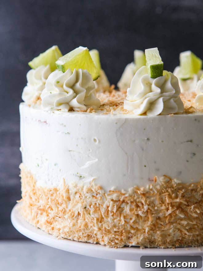 Top view of decorated Coconut Lime Layer Cake with toasted coconut and lime slices