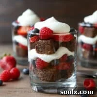 Layered brownie berry trifles assembled in glasses.