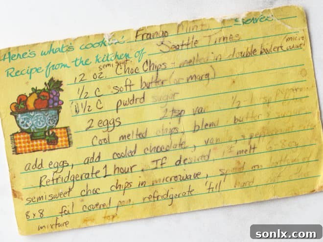 A close-up of an aged and cherished recipe card, with handwritten instructions for making Frango mint fudge, showing signs of frequent use and love.