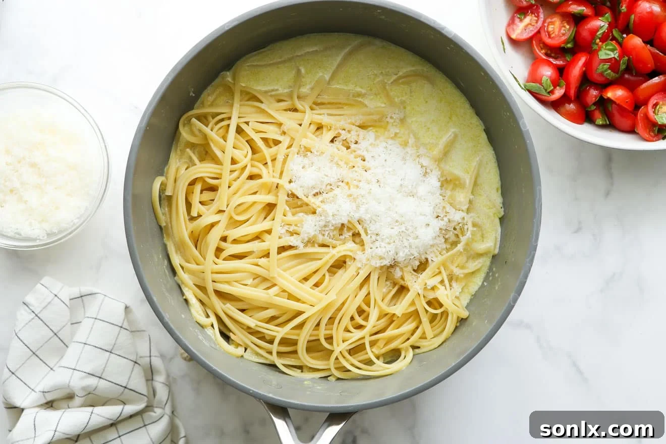 Adding cooked pasta directly into a pot filled with creamy lemon sauce, ready to be tossed.