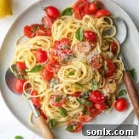 One-pot lemon pasta with tomatoes and basil served on a plate with fresh basil garnish.