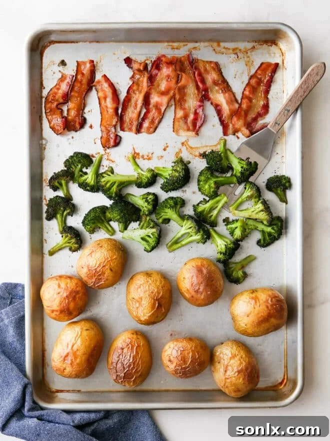 A sheet pan filled with perfectly roasted potatoes, crispy bacon, and tender broccoli, ready for toppings.