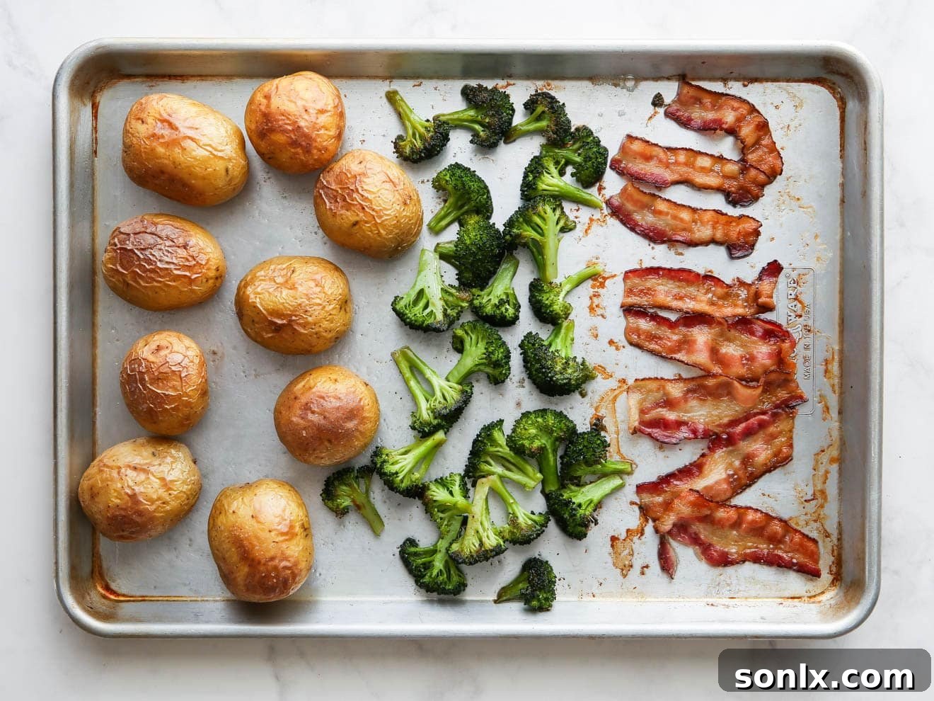 A loaded baked potato sheet pan dinner, freshly cooked and ready for final toppings and serving.