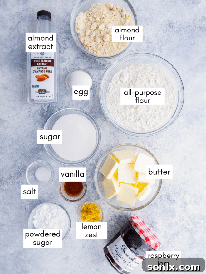 Carefully arranged fresh ingredients for baking Raspberry Almond Linzer Cookies, including flour, butter, sugar, almonds, lemon, and raspberry jam.