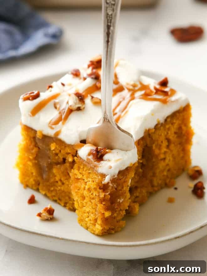 A close-up shot of a person taking a bite out of a slice of pumpkin caramel poke cake, highlighting its moist layers and rich toppings.