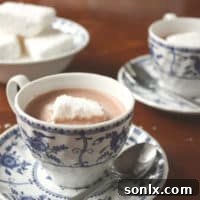 A small bowl of homemade coconut marshmallows on a wooden surface.