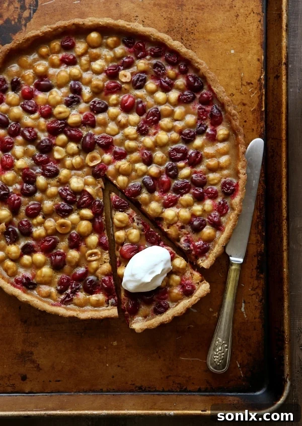 Cranberry, Caramel and Hazelnut Tart: A perfect holiday dessert with homemade caramel, fresh cranberries, and whole hazelnuts in a flaky crust.