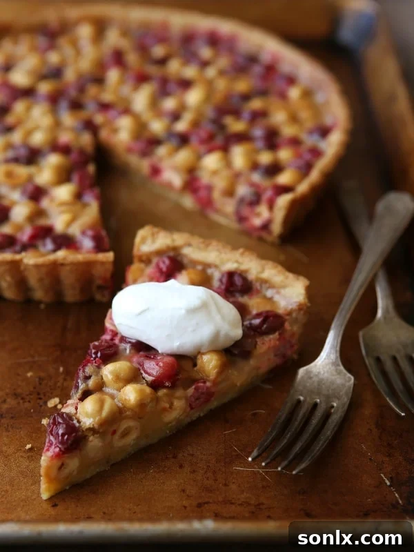 Overhead view of a Cranberry, Caramel and Hazelnut Tart, highlighting the beautiful arrangement of ingredients.