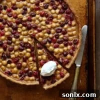Cranberry, Caramel and Hazelnut Tart: A perfect holiday dessert with homemade caramel, fresh cranberries, and whole hazelnuts in a flaky crust.