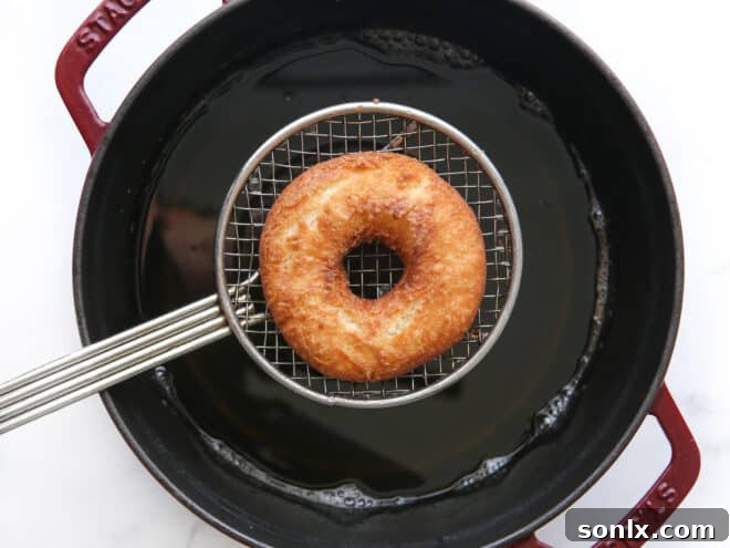 lifting fried doughnuts out of oil