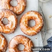 glazed old fashioned doughnuts on a wire rack with glass of milk