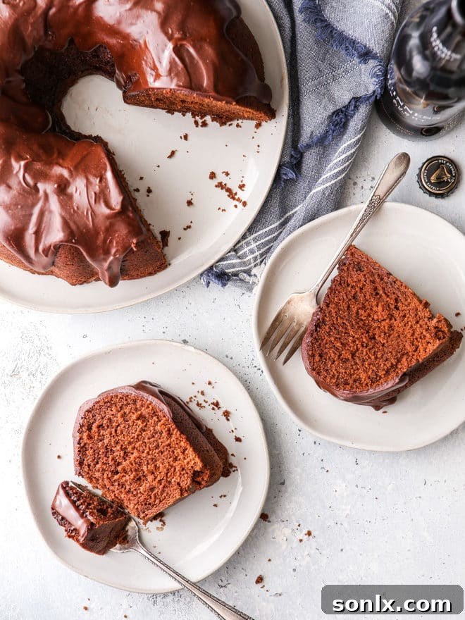 A slice of chocolate stout bundt cake showcasing its moist texture and rich ganache, highlighting the Guinness beer infusion.