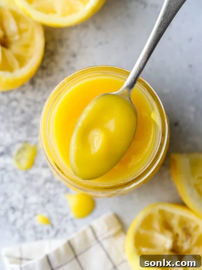 A spoonful of vibrant, glossy homemade lemon curd, ready to be enjoyed.