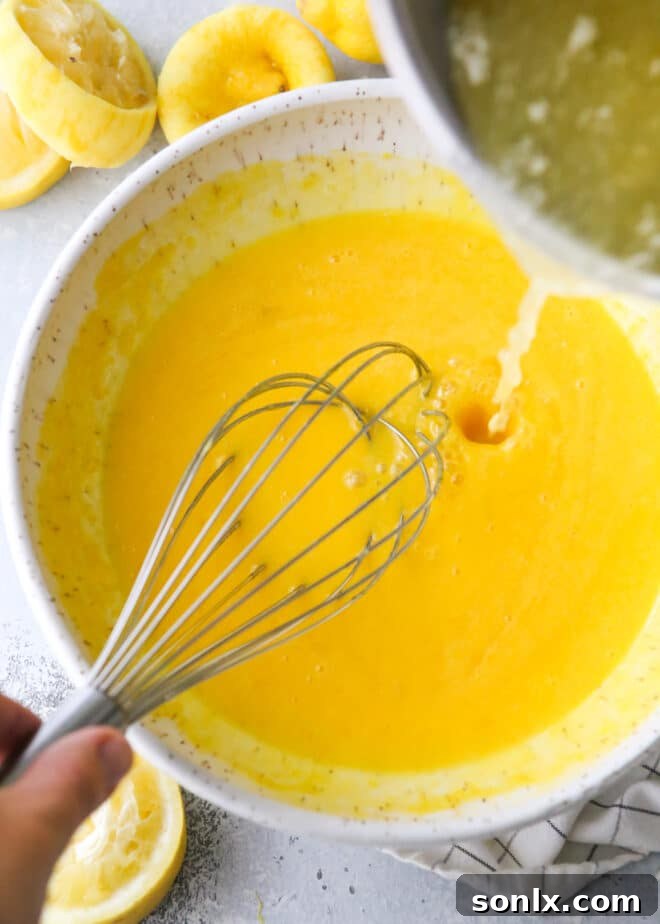 The process of slowly pouring warm lemon mixture into whisked egg yolks for tempering.