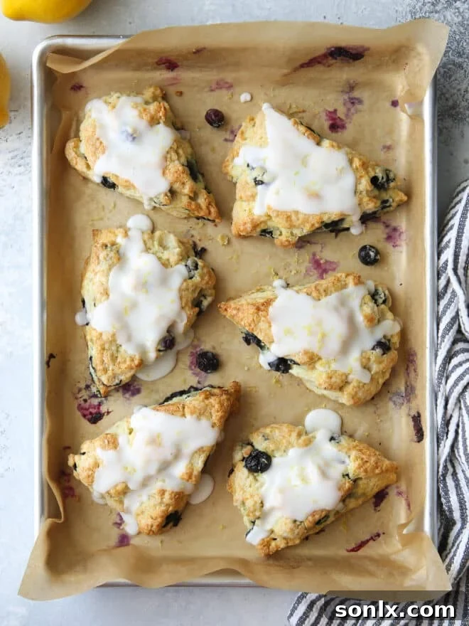 Freshly baked lemon blueberry scones on a wire rack, glazed