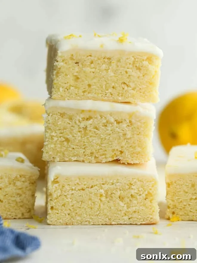Stacked lemon sugar cookie bars with zesty lemon icing
