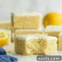 Bite taken out of a lemon sugar cookie bar with smooth icing