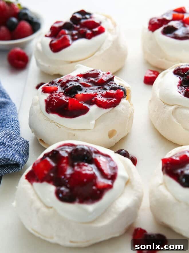 Close-up of multiple mini berry pavlovas on a serving platter, showing intricate details