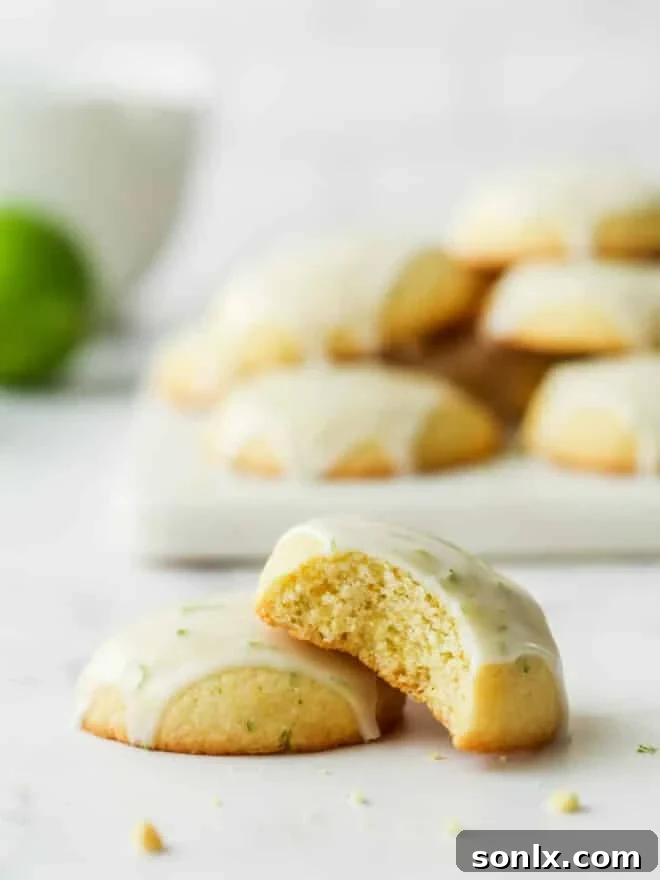 stack of lime cornmeal cookies with a bite taken out of one, revealing the textured interior
