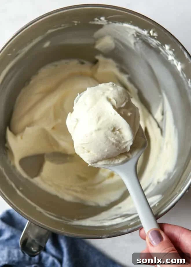 creamy chantilly frosting on spatula with bowl